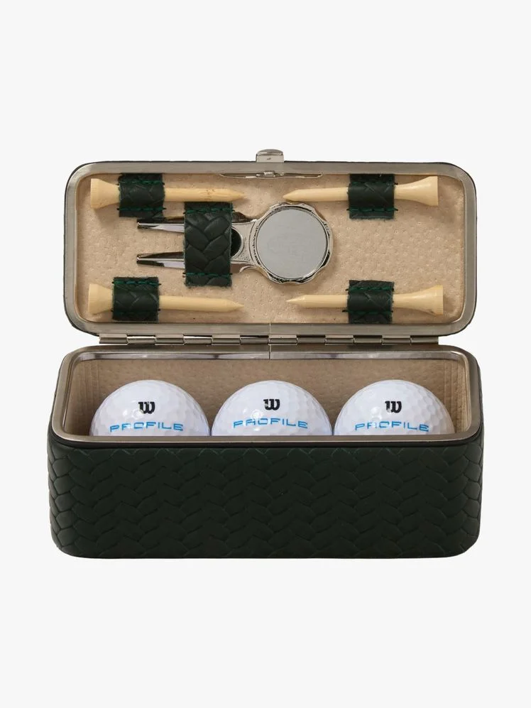 Leather box with metal hardware holding golf balls and tees.