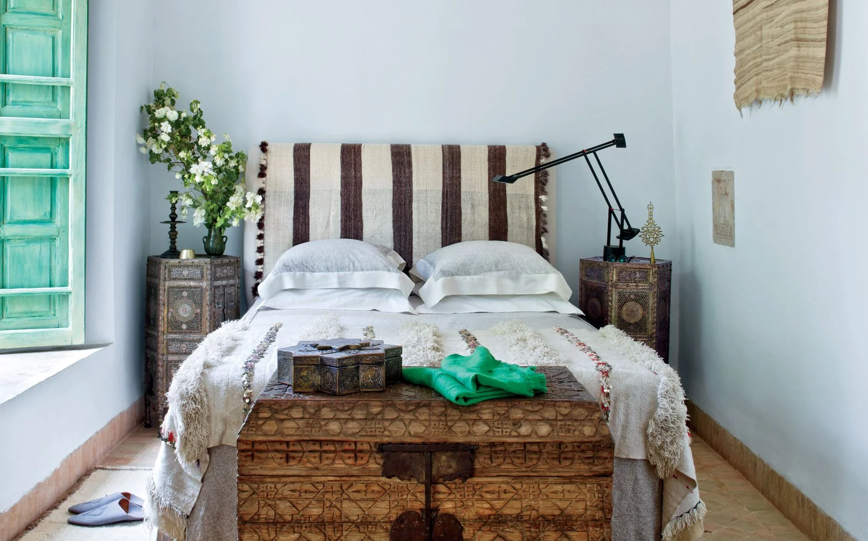 Bed with two small nightstands on either side and a striped headboard.