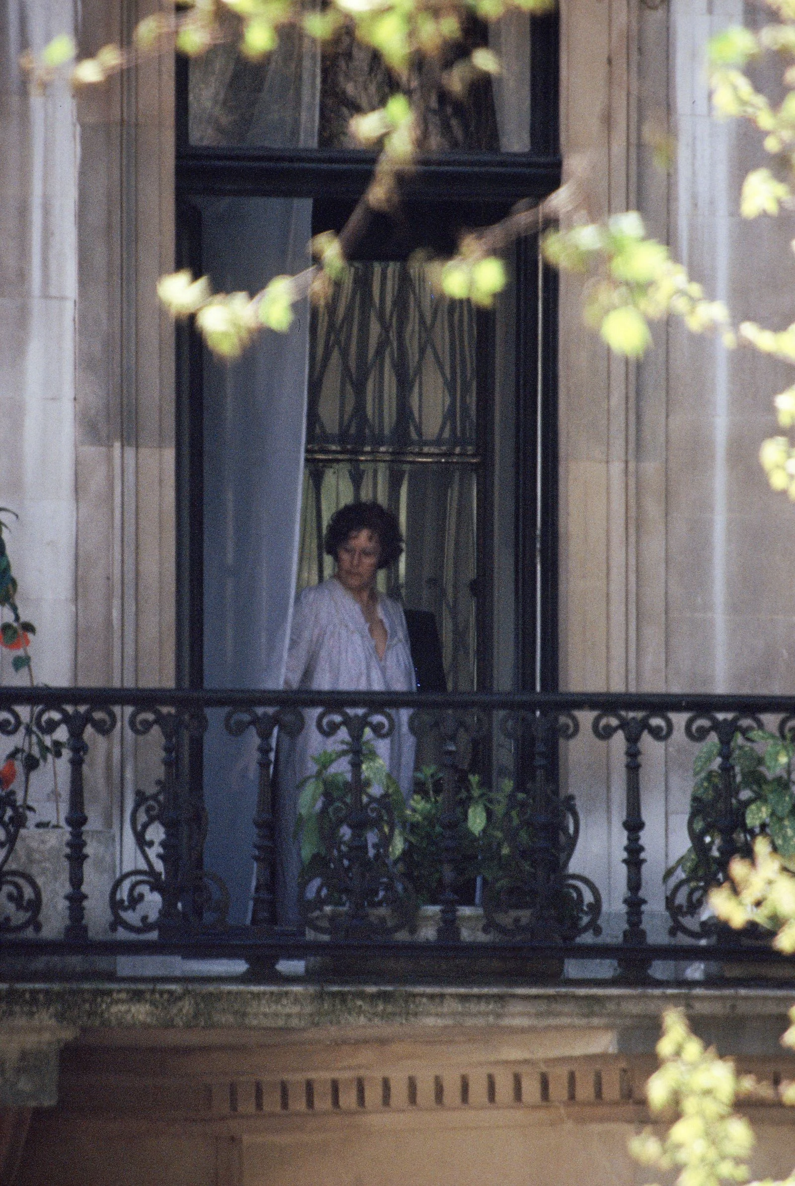 paparazzi photo of Ava Gardner seen opening a French door onto the terrace of her apartment