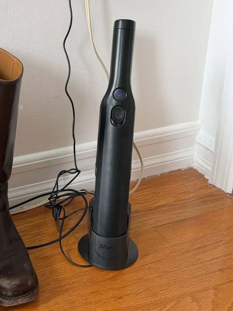 Handheld vacuum in a charging port on the floor.