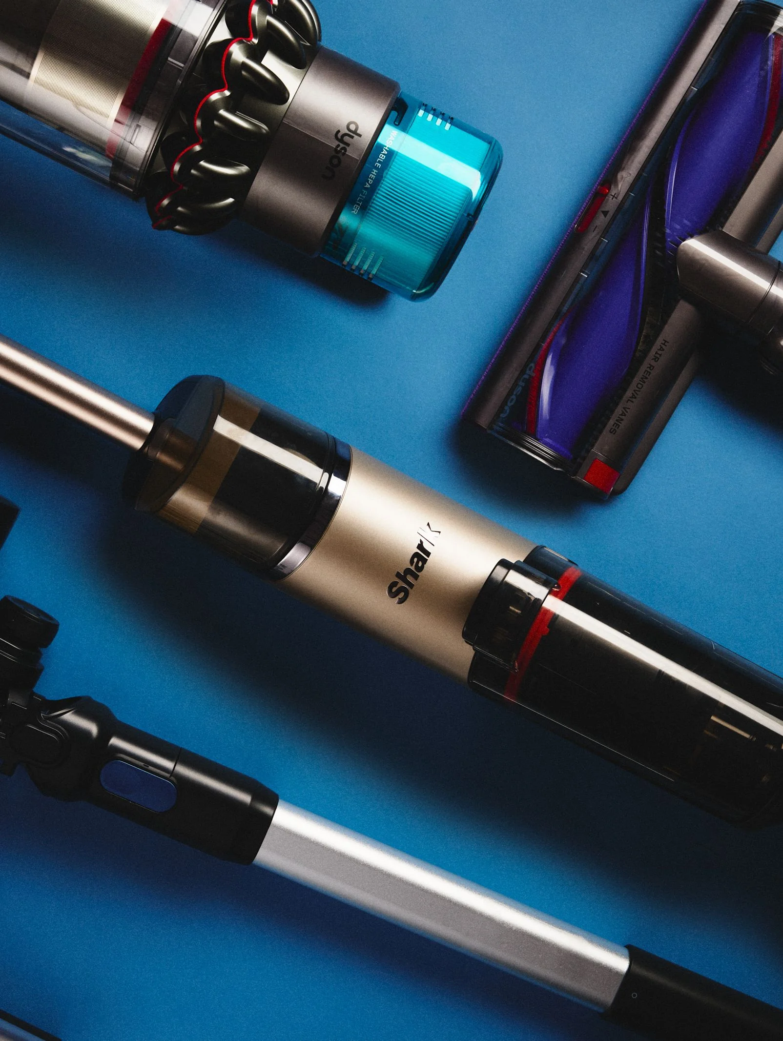 Assorted vacuums arranged on a blue surface.