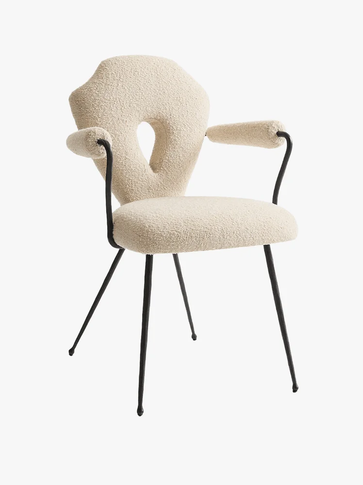 A white keyhole shaped chair with black metal legs 
