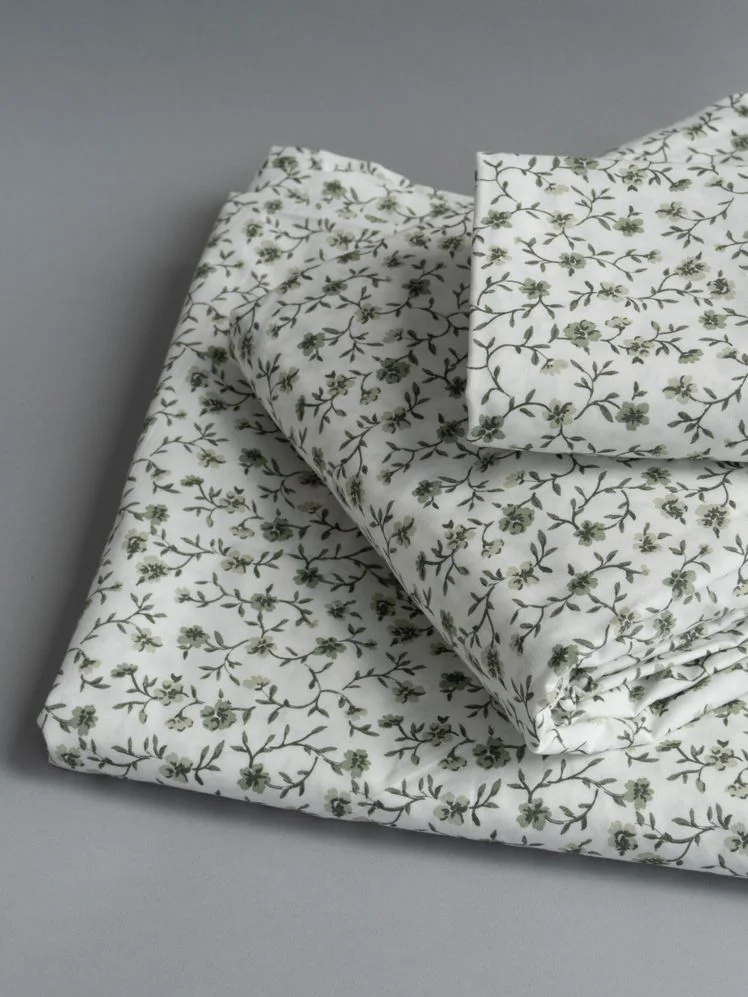 Stack of folded floral print sheets.