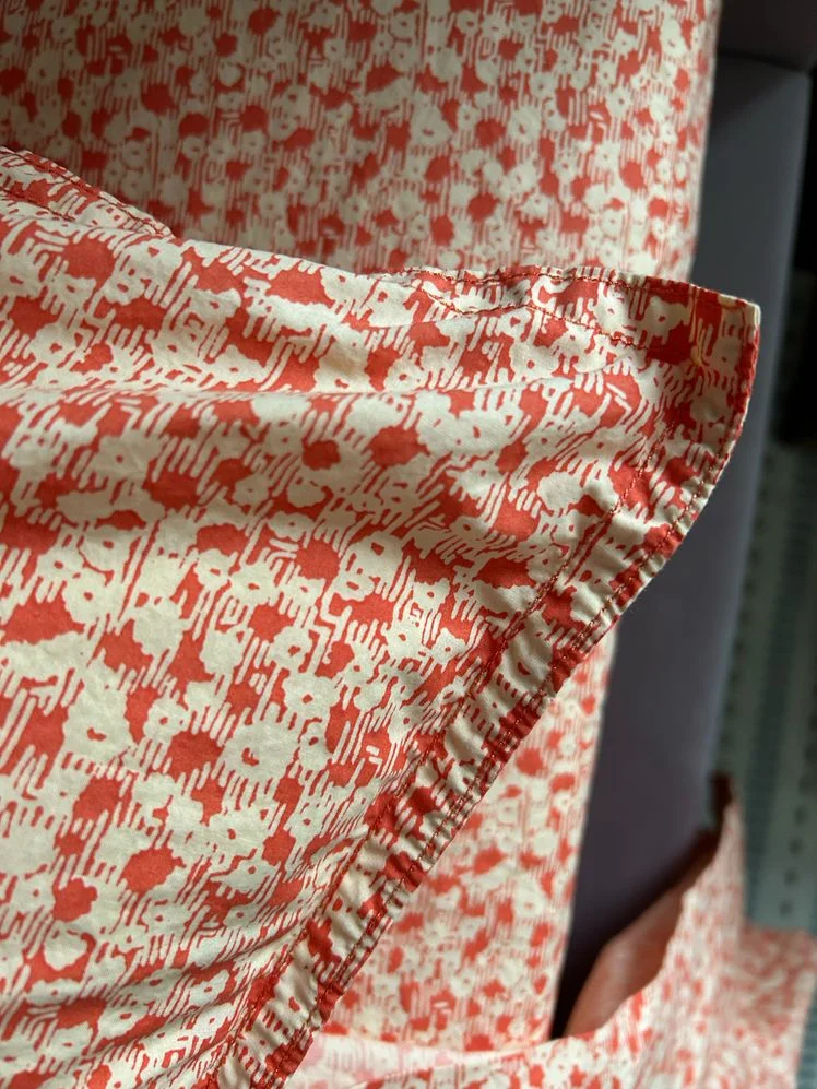 Closeup of red and tan floral sheets.