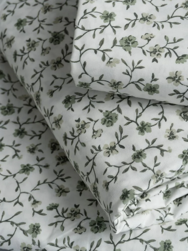 Closeup on a stack of folded floral print sheets.